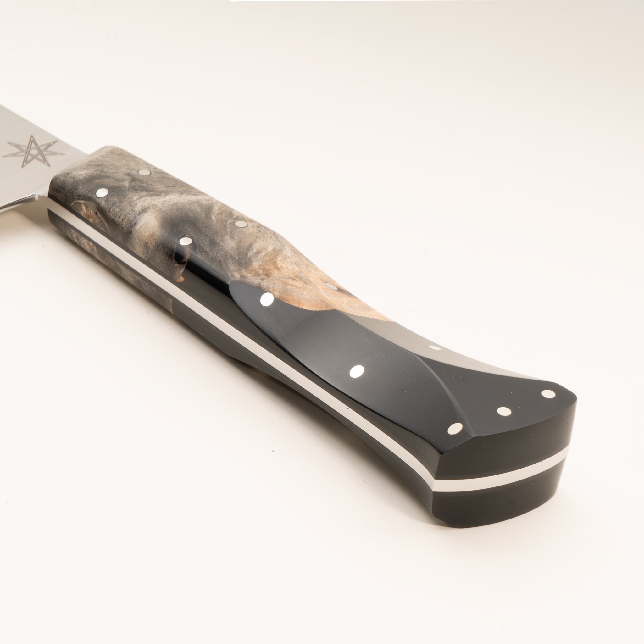 Close-up of a kitchen chef knife handle made from wood and black resin, on a white background.