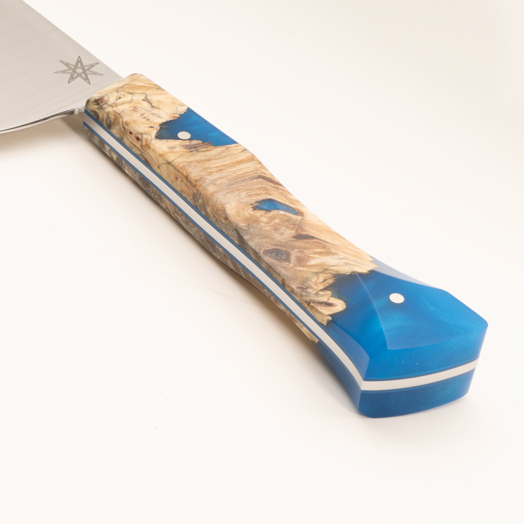 Detail photo of knife handle of Tahoe Bliss stainless steel chef knife with buckeye burl wood and blue resin handle by Town Cutler.