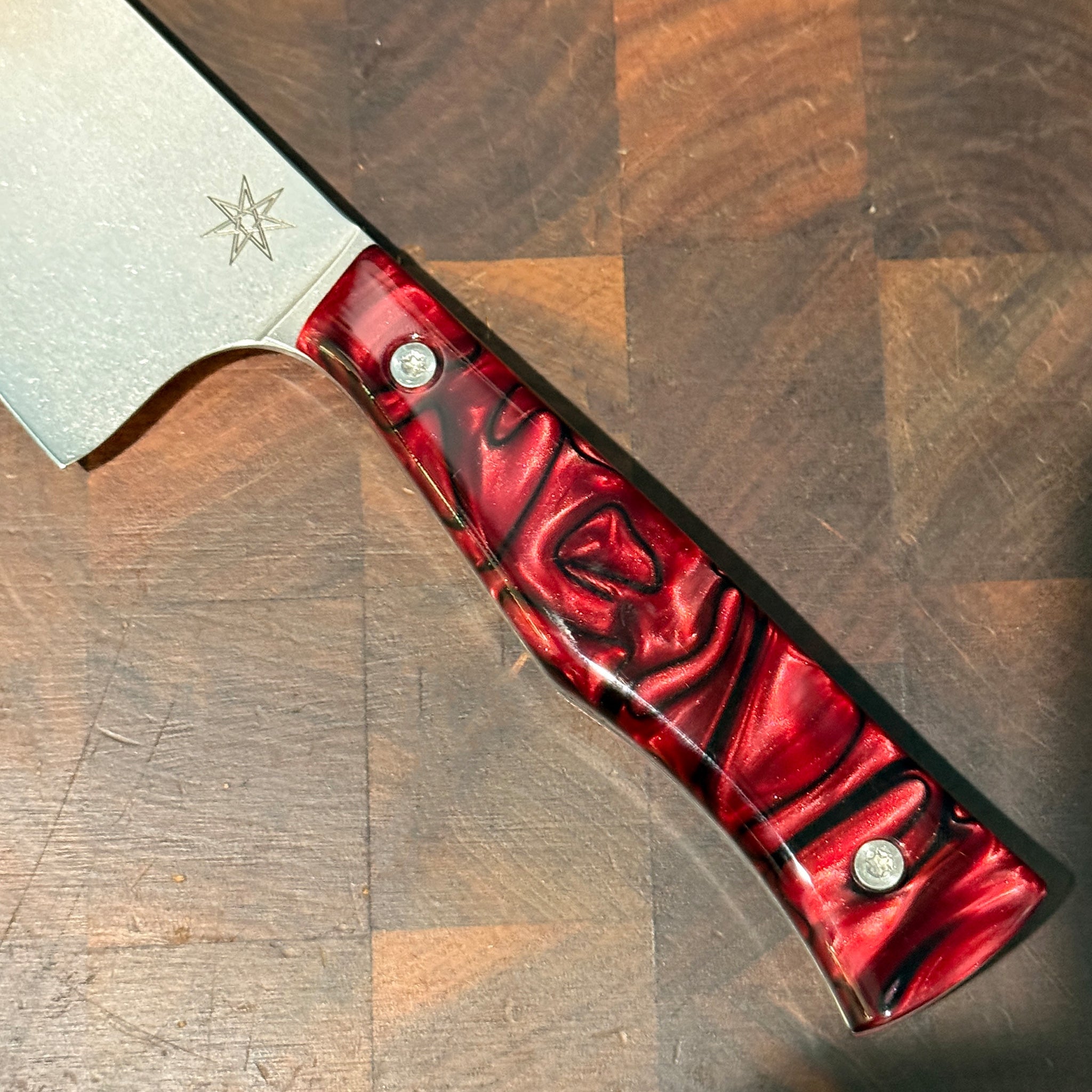 Knife with a red handle on a wooden surface
