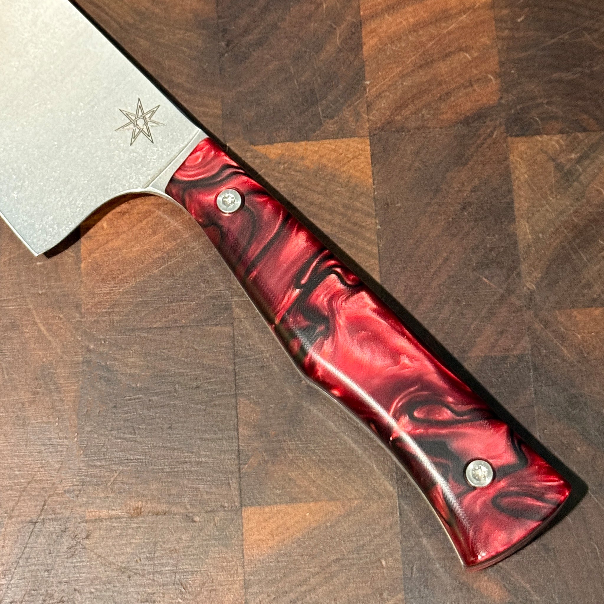 Knife with a red and black handle on a wooden surface